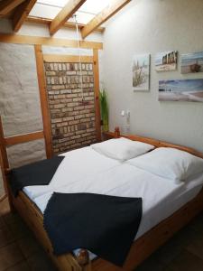 - une chambre avec un grand lit et des draps blancs dans l'établissement Ferienhaus Priepert, à Priepert