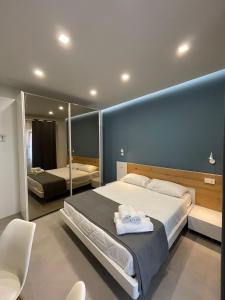 1 dormitorio con 1 cama grande y pared azul en B&Benny, en Reggio Calabria
