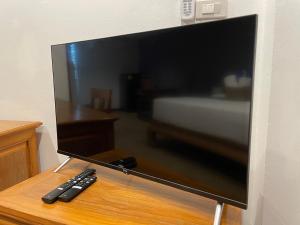 uno schermo televisivo con due telecomandi su un tavolo di The Pavillon by The Pace Phuket Boutique Resort a Rawai Beach