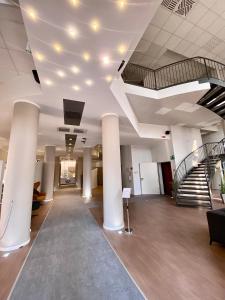 a lobby with columns and a staircase in a building at Break Hotel in Ospedaletto Lodigiano