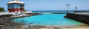 a pool of blue water next to a lighthouse at Casa Bela in Arrieta
