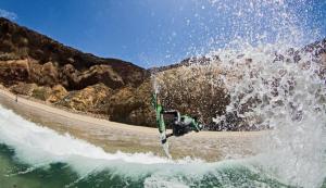 un homme faisant une vague sur une planche de surf dans l'eau dans l'établissement Arránquese de la lluvia y disfrute de días soleados en la Playa Los Molles con buen clima en acogedora cabaña, à Los Molles