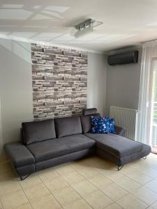 um sofá numa sala de estar com uma parede de tijolos em Levi's wellness apartman em Siófok