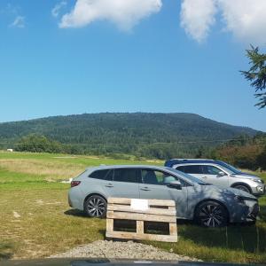 two cars parked next to a sign in a field at Parking pod Luboniem Wielkim in Zaryte