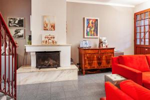 a living room with a fireplace and a red couch at A Room for You in Ferrara