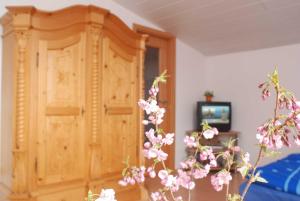 ein Schlafzimmer mit einem Holzschrank und rosa Blumen in der Unterkunft Ferienwohnung Pferdezentrum Edersee in Waldeck