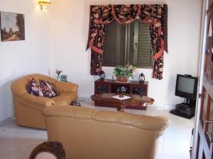 a living room with a couch and a table at Bungalow with 2 double bedrooms in the hills . in Akoursos