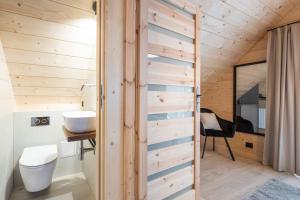 - une salle de bains avec un mur en bois dans une maison dans l'établissement Osada Chłabówka Zakopane & SPA, à Zakopane