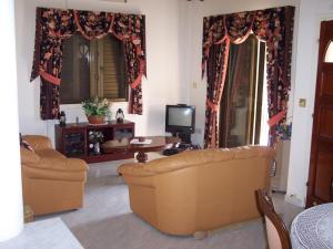 a living room with two couches and a tv at Bungalow with 2 double bedrooms in the hills . in Akoursos