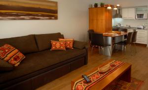 a living room with a brown couch and a table at Bariloche Down Town Apartment in San Carlos de Bariloche