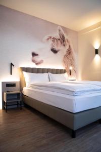 a bedroom with a bed with a picture of animals on the wall at Adaastra Boutique Hotel in Naters