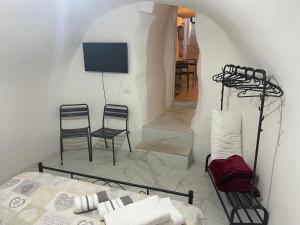 1 dormitorio con 2 sillas, 1 cama y TV en Mory&Clary Cave Palese Airport en Bari Palese