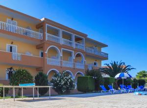 a building on the beach with chairs and an umbrella at Derekas studios & apartments in Laganas