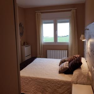 a bedroom with a bed with two pillows on it at Apartamento en playa de Foz in Foz