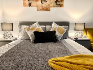 una camera da letto con un letto con cuscini e due lampade di Beautiful Studio apartment in a house with parking a Erith