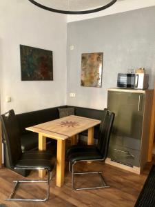 uma mesa e duas cadeiras e uma mesa e um frigorífico em Delux Ferienwohnung Kunstgalerie und Ilmradweg em Kranichfeld