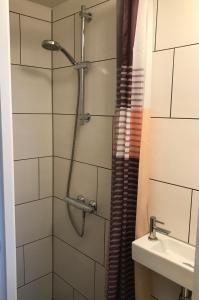 La salle de bains est pourvue d'une douche et d'un lavabo. dans l'établissement B&B Kogervennetje, à De Koog