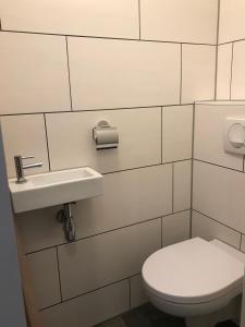 Baño blanco con aseo y lavamanos en B&B Kogervennetje en De Koog