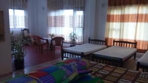 une chambre avec deux lits, une table et des fenêtres dans l'établissement Southern Heritage Holiday Resort, à Deniyaya 21 autres photos