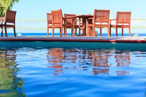 um grupo de cadeiras e uma mesa ao lado de uma piscina em Funky Fish Beach & Surf Resort em Malolo