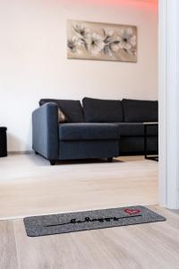 a living room with a black couch and a rug at Apartmani Park Maksimir-Rebro in Zagreb