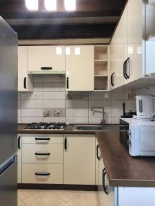uma cozinha com armários brancos e um forno com placa de fogão em Happy House em Slavske