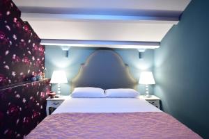 - une chambre bleue avec un lit et deux lampes dans l'établissement Queen 2,heart of Corfu Historical Old Town Center!, à Corfou