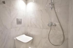 La salle de bains blanche est pourvue d'une douche et de toilettes. dans l'établissement Queen 2,heart of Corfu Historical Old Town Center!, à Corfou