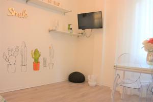 a dining room with a table and a tv on the wall at Sea&Bike_Apartment in Finale Ligure