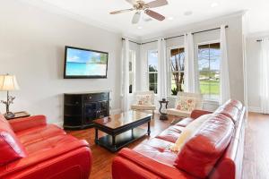 a living room with a red couch and a table at 4 Bedroom house on the golf course with 2 golf carts! in Destin