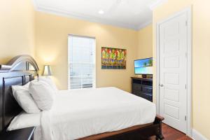 a bedroom with a white bed and a television at 4 Bedroom house on the golf course with 2 golf carts! in Destin