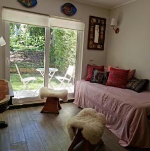 a bedroom with a bed and a window with a patio at Departamento en la naturaleza de Pucón in Pucón