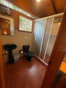 a bathroom with a green toilet and a sink at Caoni riverside Lodge in Puerto Quito