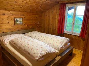 a bedroom with two beds in a log cabin at Chalet - Haus Ahorn Ost in Hasliberg