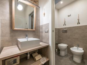 a bathroom with a sink and a toilet and a mirror at Studio 73 in Cagliari