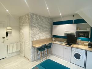a kitchen with white cabinets and blue accents at Studio Confort Lorient Rue Vauban Hypercentre in Lorient