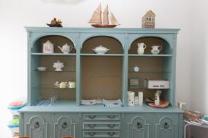 a blue hutch with various items on it at la Brunita in Rubiera