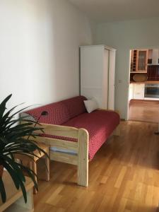 a red couch in a room with a kitchen at Ferienwohnung Kastanienblick oder Parkblick in Ziethen