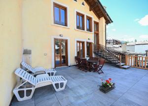 a patio with chairs and tables on a house at Il Fouia Apartments in Pragelato