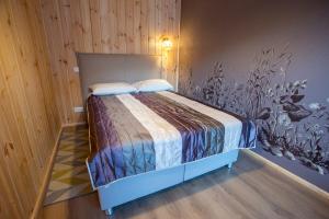 una camera da letto con un letto in una parete di legno di Brīvdienu māja mierpilnai ģimenes atpūtai Siltumnīca a VEF-Skulte