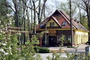 a yellow house with a brown roof at Villa Hotel in Debrecen