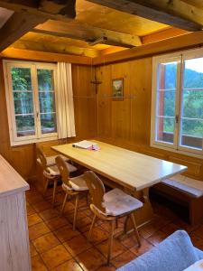 ein Esszimmer mit einem Holztisch und Stühlen in der Unterkunft Chalet - Haus Ahorn Ost in Hasliberg