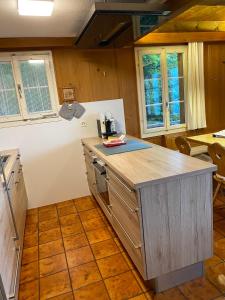 cocina con encimera de madera y algunas ventanas en Chalet - Haus Ahorn Ost, en Hasliberg