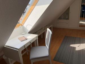 a desk and a chair in a room with a attic at Ankerplatz Warnemünde - Direkte Strandnähe mit Leuchtturmblick in Warnemünde +13 photos