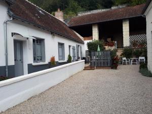 ein weißes Haus mit einer Veranda und einer Terrasse in der Unterkunft gite de la tour carrée in Montrichard