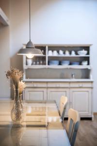a dining room table with a vase with flowers in it at Bogen bistro & apartments in Bolzano