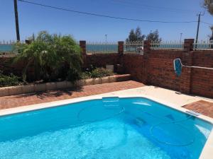 a large blue swimming pool in a backyard at Beach House Opposite Ocean 4 Bed 2 Bathroom with pool in Geraldton