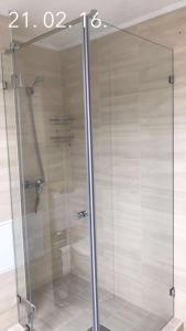 a shower with a glass door in a bathroom at Boglárka Apartmanház in Balatonfüred