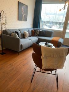 a living room with a couch and a table at IJsvogel Apartment, Duplex Family Home 4-bed located on the largest saltwater lake in Bruinisse