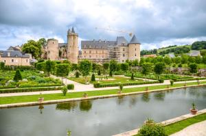 a large castle with a river in front of it at La Maison Mescladis in Manhac